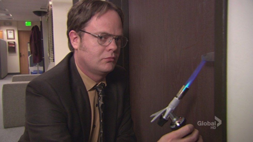 Dwight holding a flame to a door handle in The Office