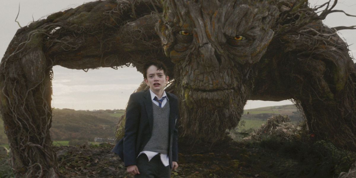 Conor with teary eyes and the tree monster looking ahead in A Monster Calls