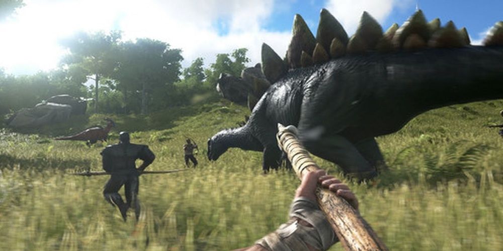 Um grupo de jogadores correndo em direção aos dinossauros, segurando lanças e arcos, em ARK Survival Evolved.
