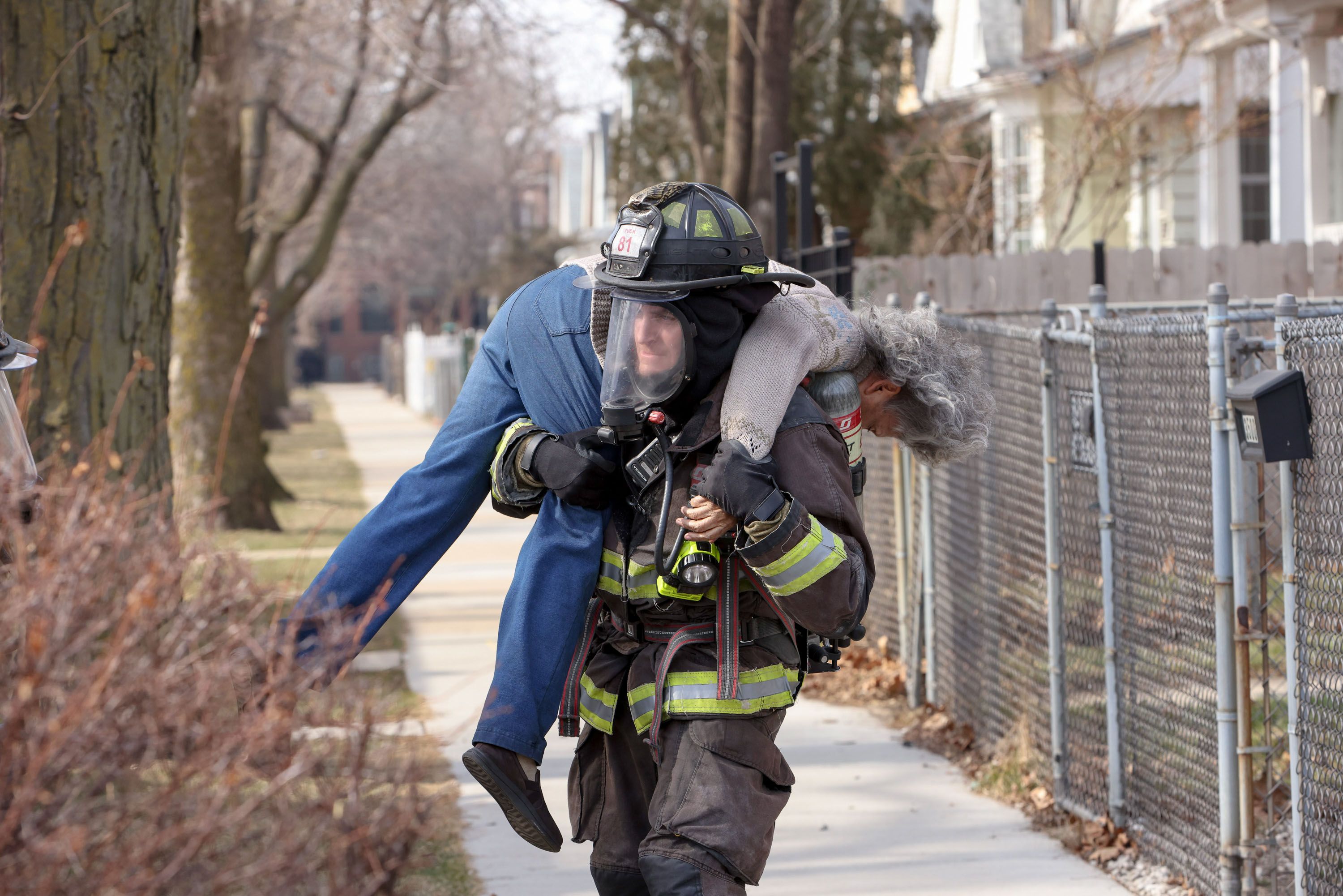 A firefighter carries a fire victim on their back in Chicago Fire Season 12