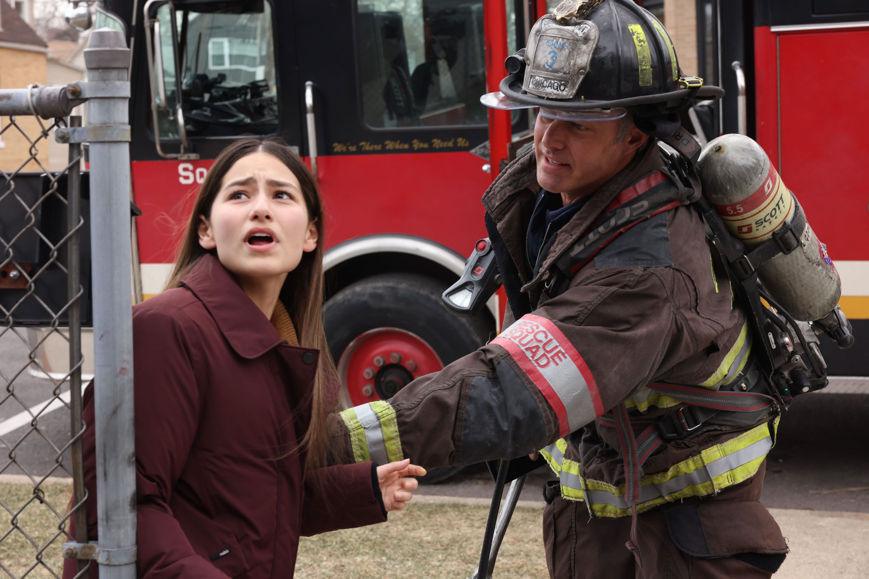 Kelly Severide (actor Taylor Kinney) holds back a young woman in Chicago Fire