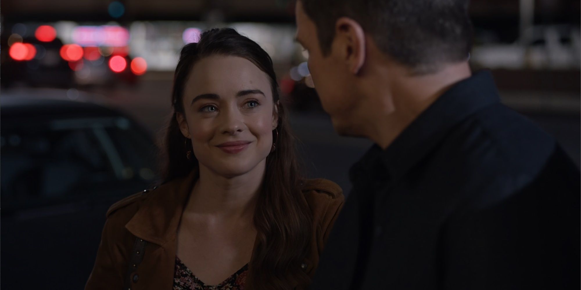 Erin Cole smiles at John Nolan, facing away from camera, outside of a bar from The Rookie