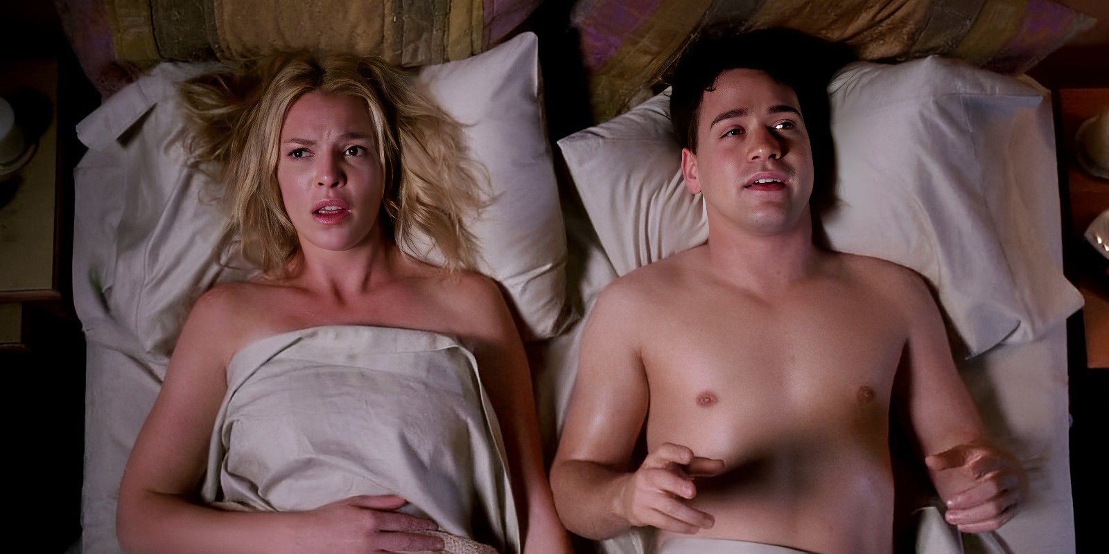 George laying shirtless in bed looking dazed next to a confused Izzie in Grey's Anatomy.