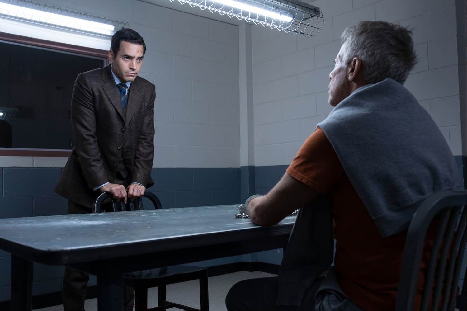 Greg Germann as James Ulster with Ramon Rodriguez as Will Trent looking at each other in an interrogation room 2