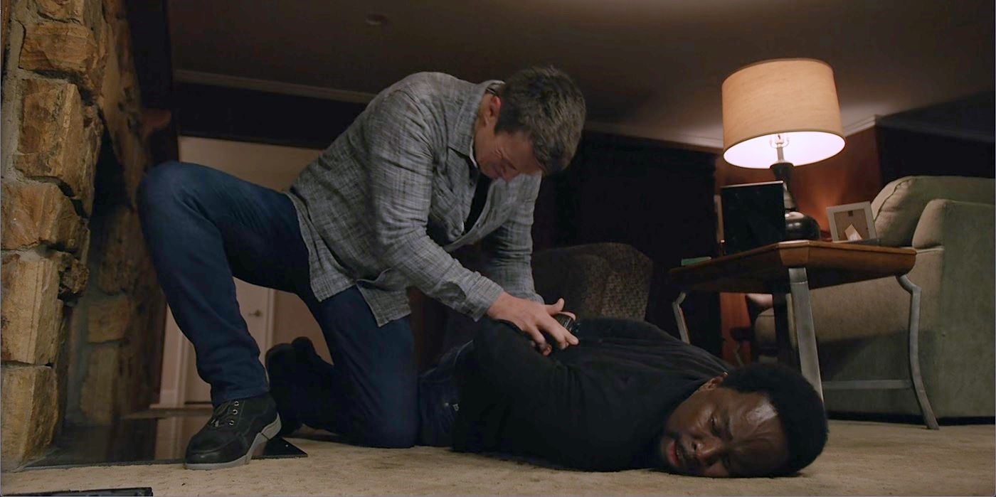 John Nolan algema Nick Armstrong, deitado no chão, em sua casa do The Rookie