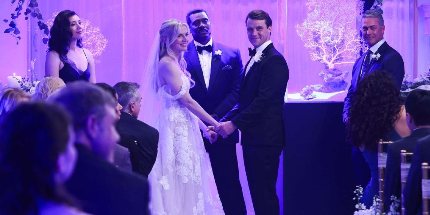 Kara Killmer in a wedding dress as Sylvie Brett stands at the front of a room across from Jesse Spencer as Matt Casey with Hanako Greensmith as Violet Mikami, Eamonn Walker as Wallace Boden, and Taylor Kinney as Kelly Severide stand around