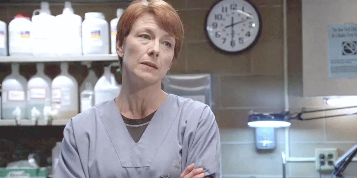 ME Elizabeth Rodgers luce molesta con los brazos cruzados en la morgue en Law & Order