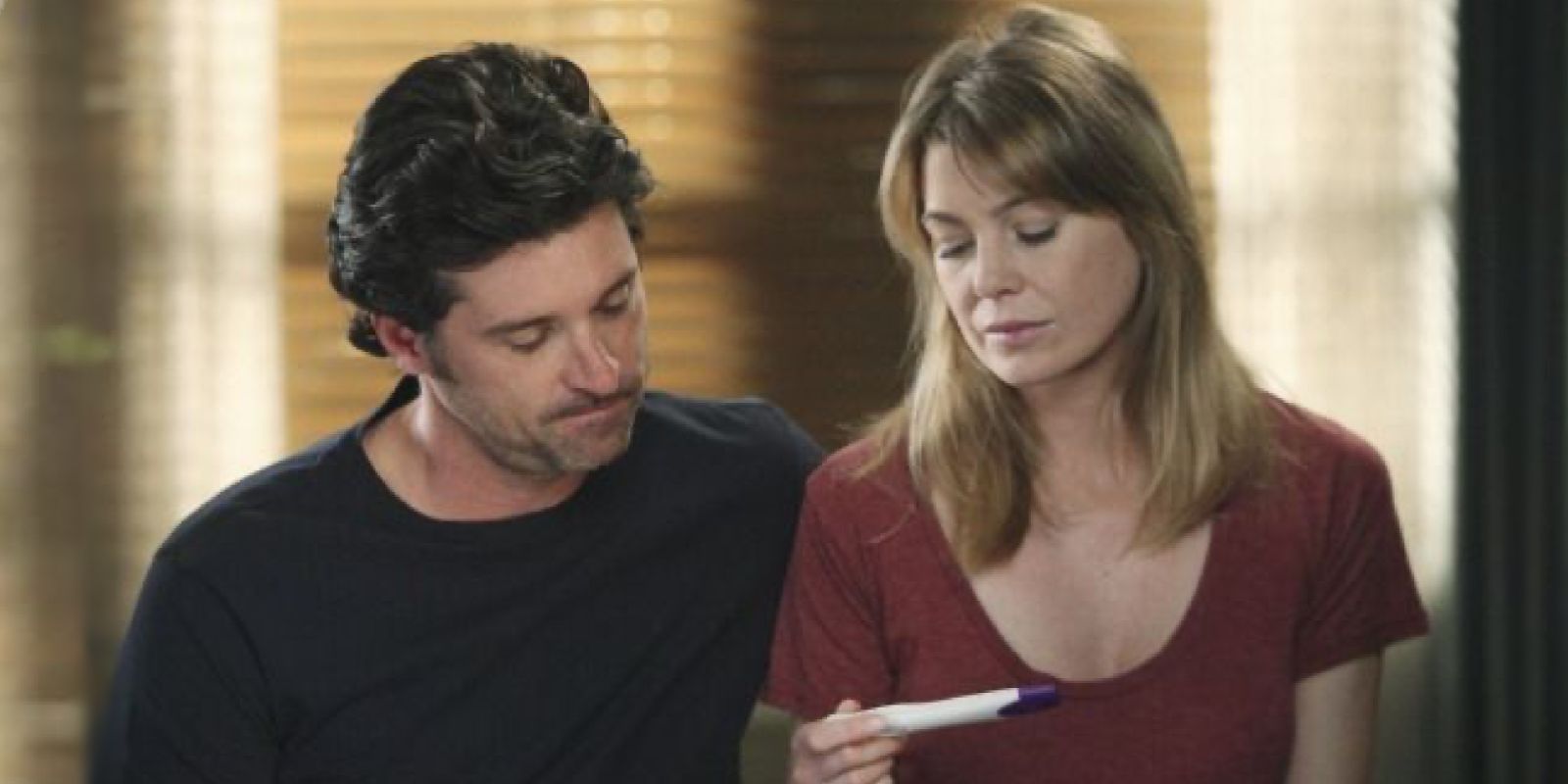 Derek and Meredith look down disappointed at a negative pregnancy test in Grey's Anatomy.