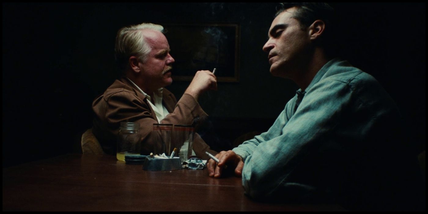 Philip Seymour Hoffman and Joaquin Phoenix sit at a table in The Master