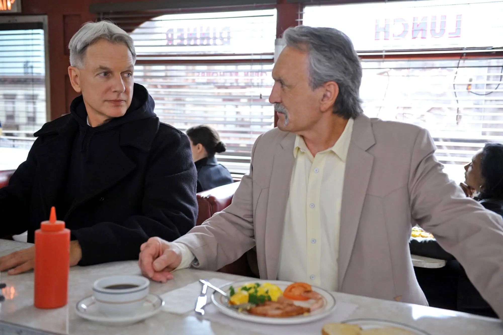 muse watson as mike franks and mark harmon as gibbs eat at a diner