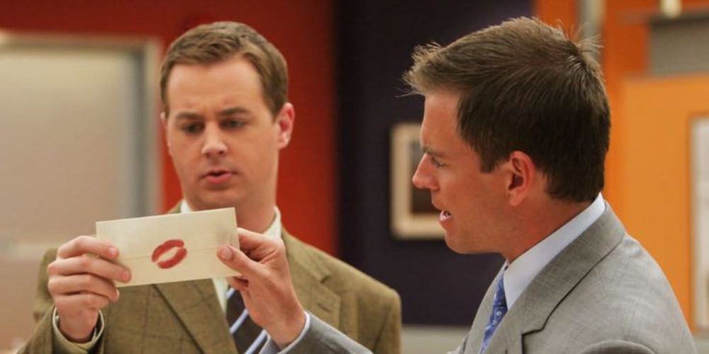 Tony and McGee holding up the poisoned note in NCIS episode SWAK