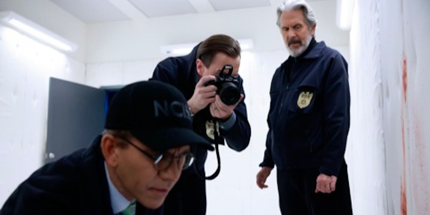 Timothy McGee (actor Sean Murray) photographs a scene between Jimmy Palmer and Alden Parker in NCIS
