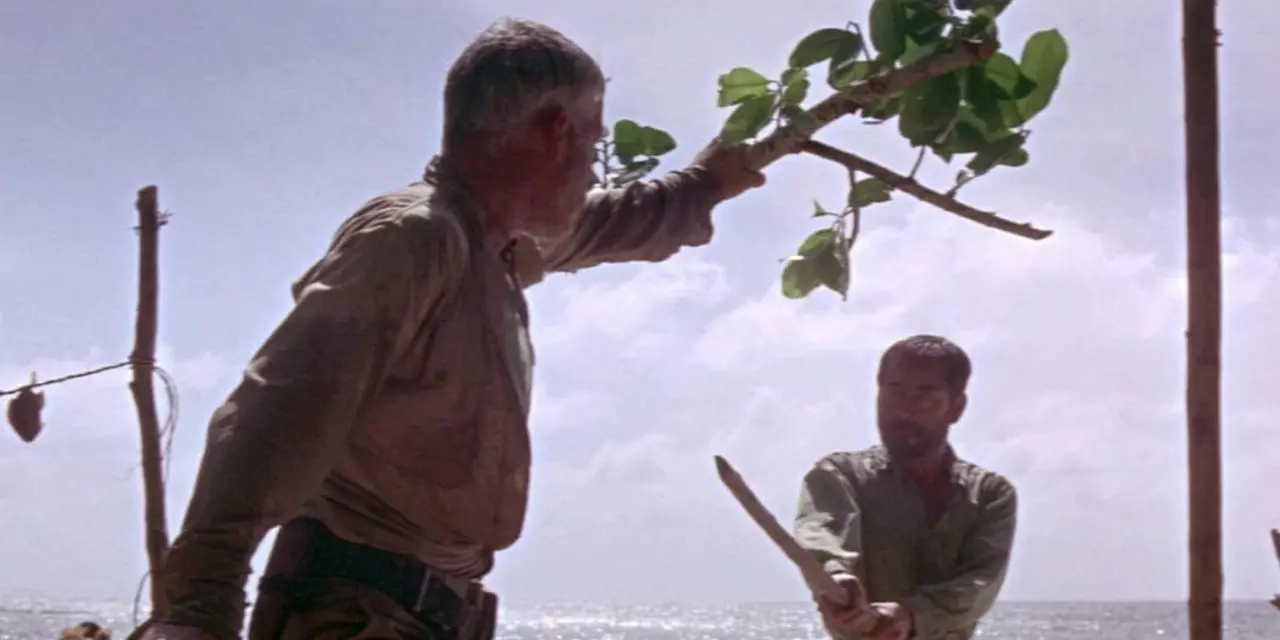 Lee Marvin looking a Toshirô Mifune brandishing a stick sword on a desert island in Hell in the Pacific (1968)