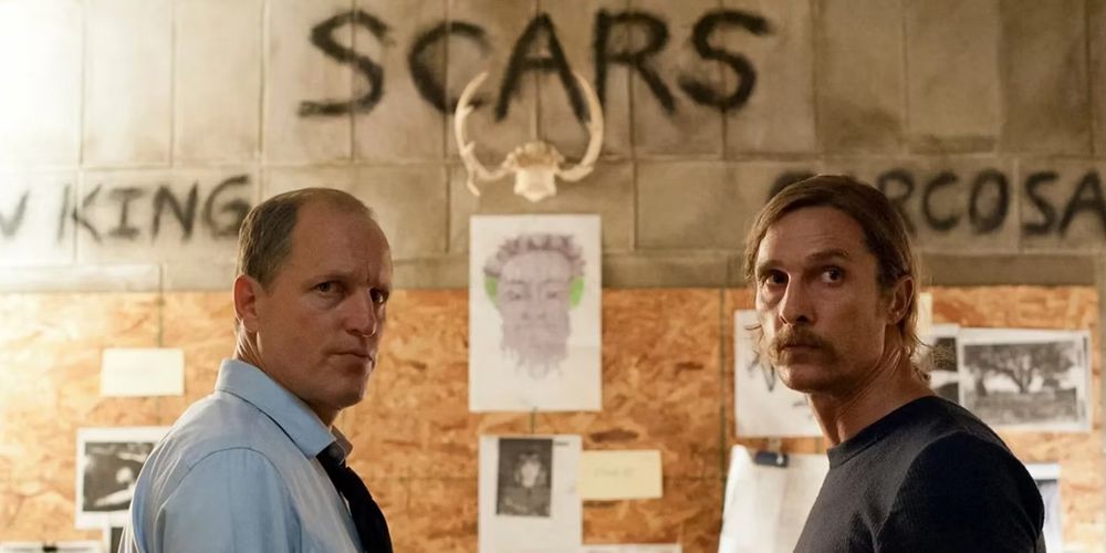 Rusty e Marty ficam em frente à parede de evidências em True Detective