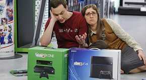 Sheldon trying to decide between Xbox One and PS4 with Amy looking miserable in The Big Bang Theory