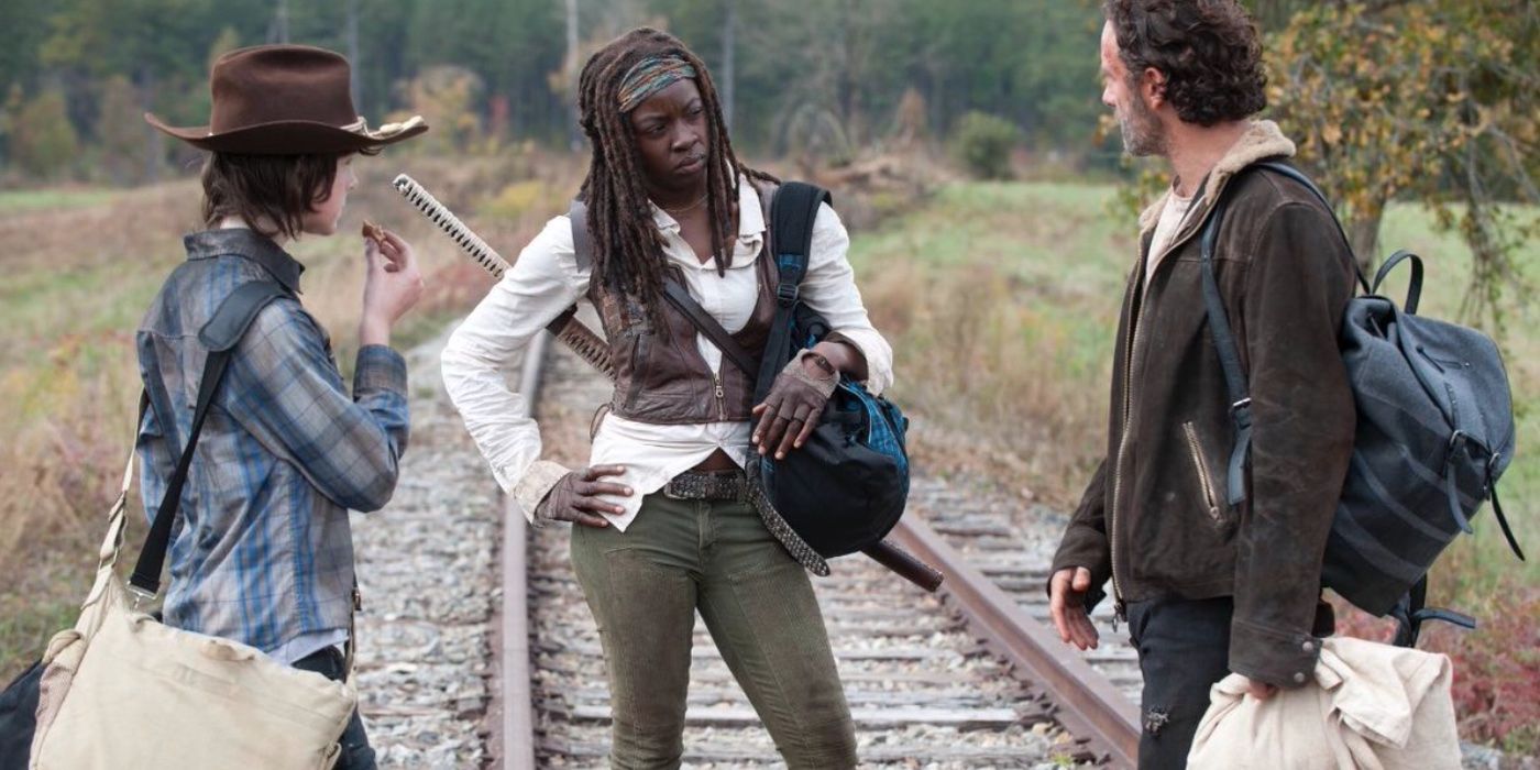 Carl Grimes, Michonne and Rick Grimes talking on the train tracks on The Walking Dead