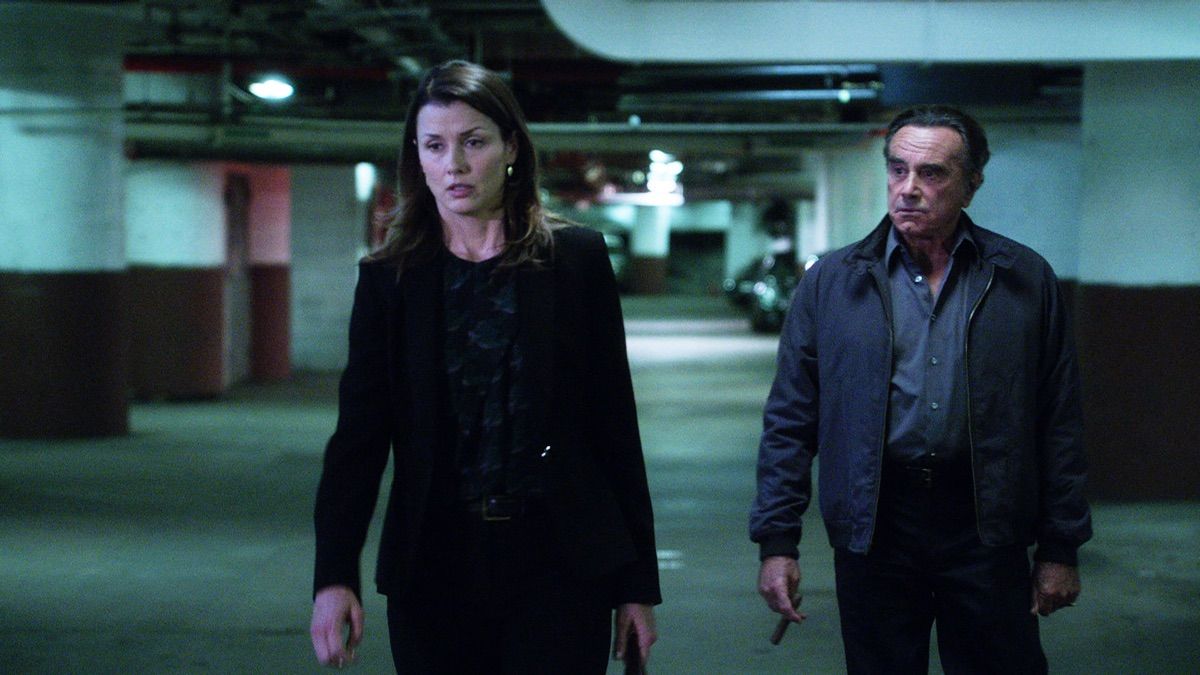 Two characters from Blue Bloods walk together in a parking lot