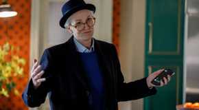 Sazz Pataki shrugging her shoulders and holding up a phone in Only Murders in the Building.