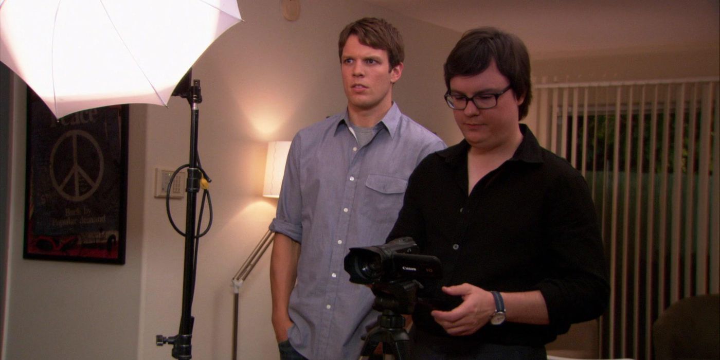 Clark Green holds a camera while Pete Miller stands behind him in The Office