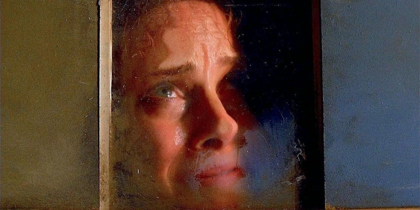 A victim looks scared and crying while held inside a small glass box in the Criminal Minds episode Scared to Death