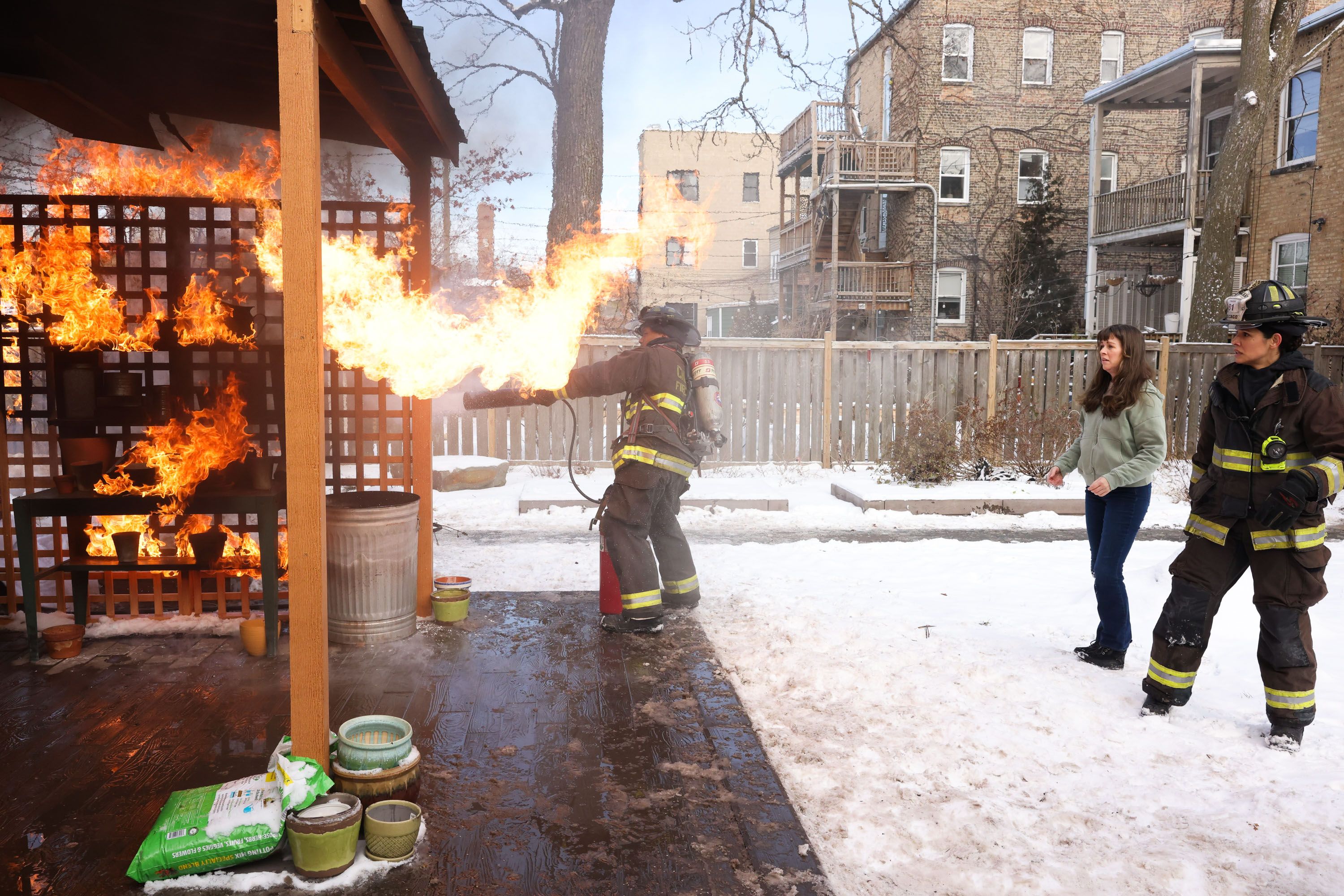 Firefighters work to put out a fire in a house's backyard in Chicago Fire Season 12