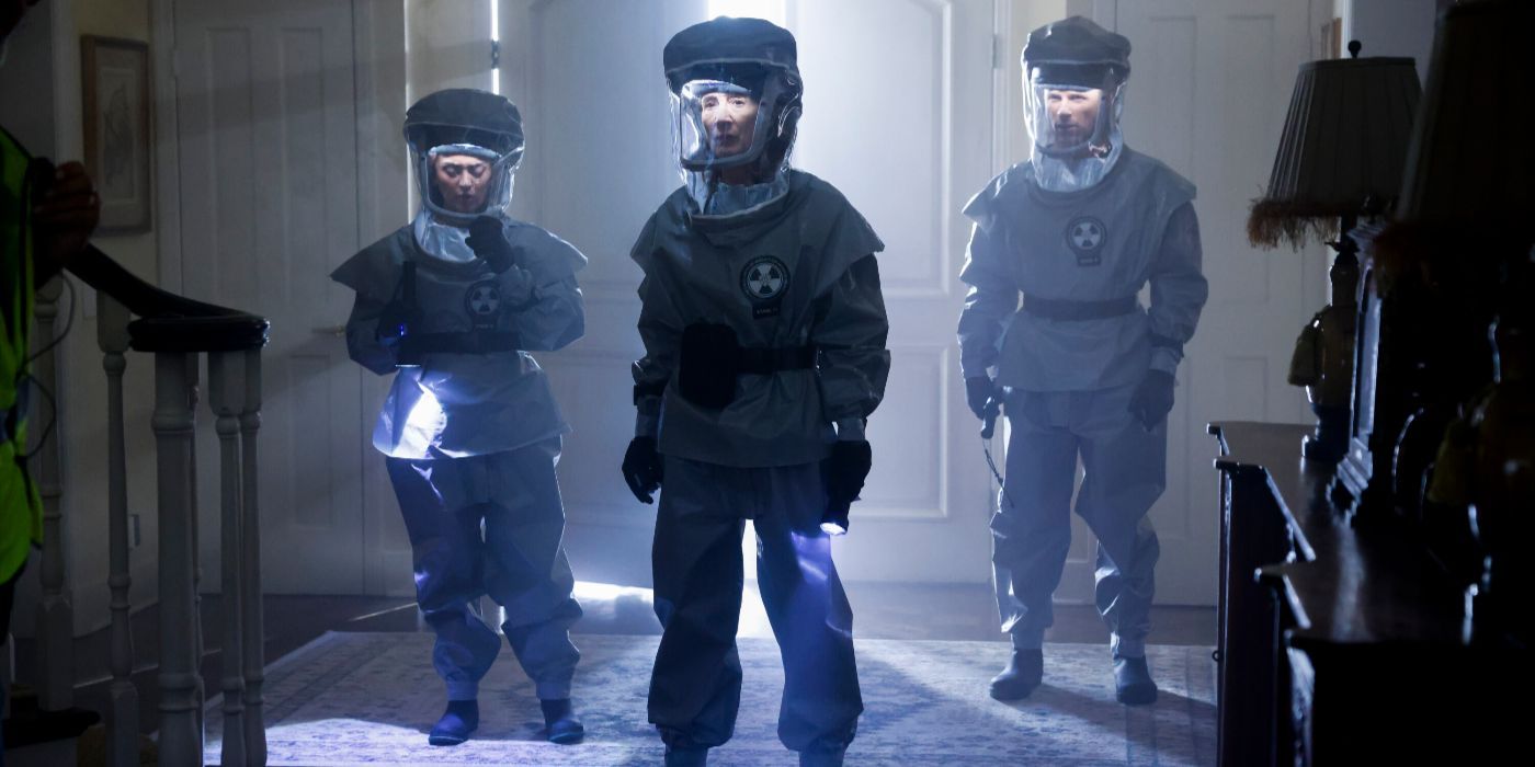 Team members stand inside a house entryway in blue radiation suits on CSI: Vegas