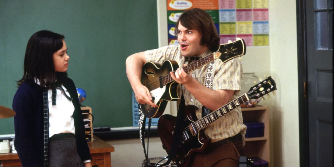 Jack Black as Dewey Finn playing multiple guitars for a student in class in School of Rock