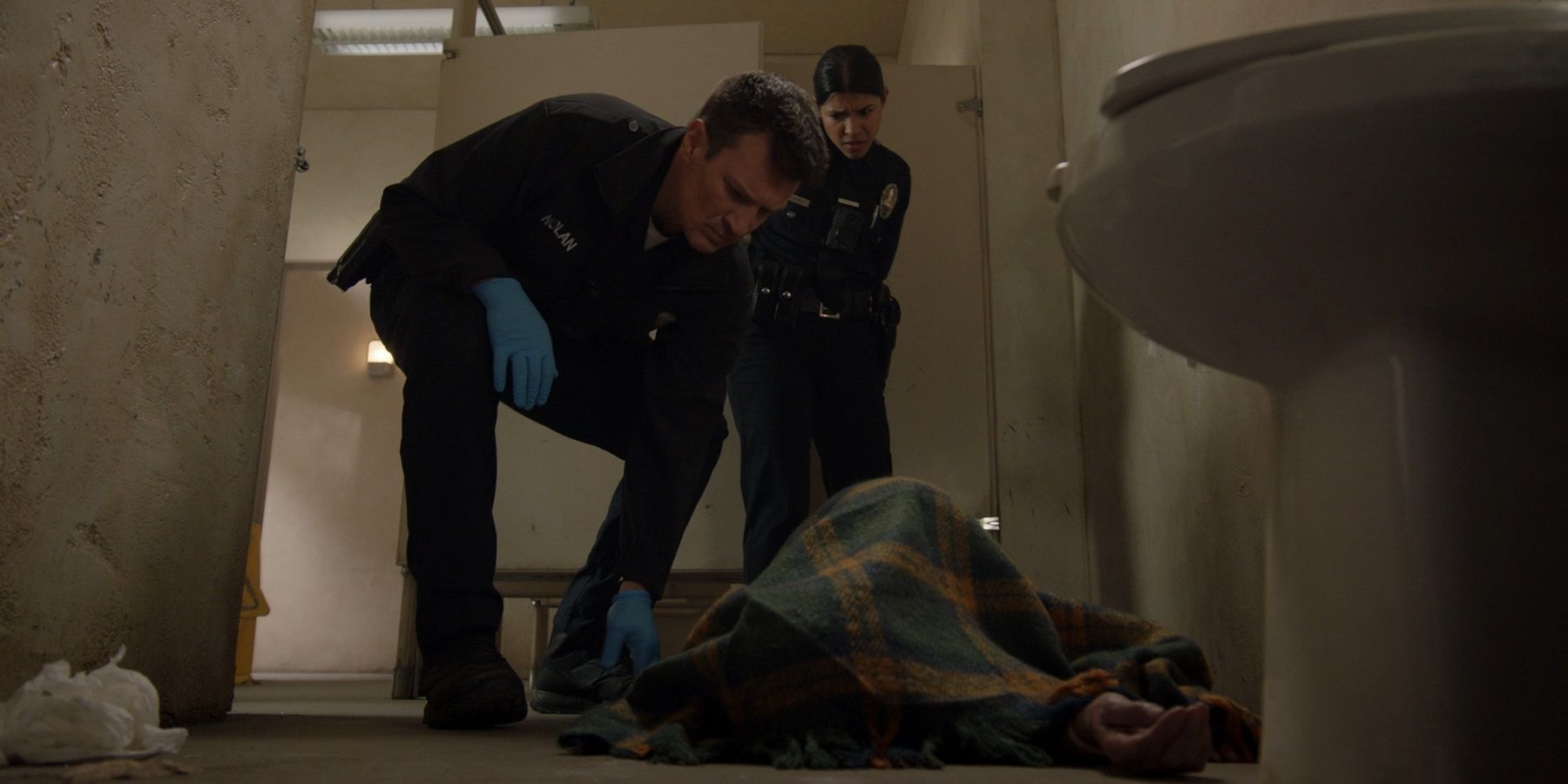 John Nolan e Celina Juarez encontram um cadáver em um banheiro em The Rookie