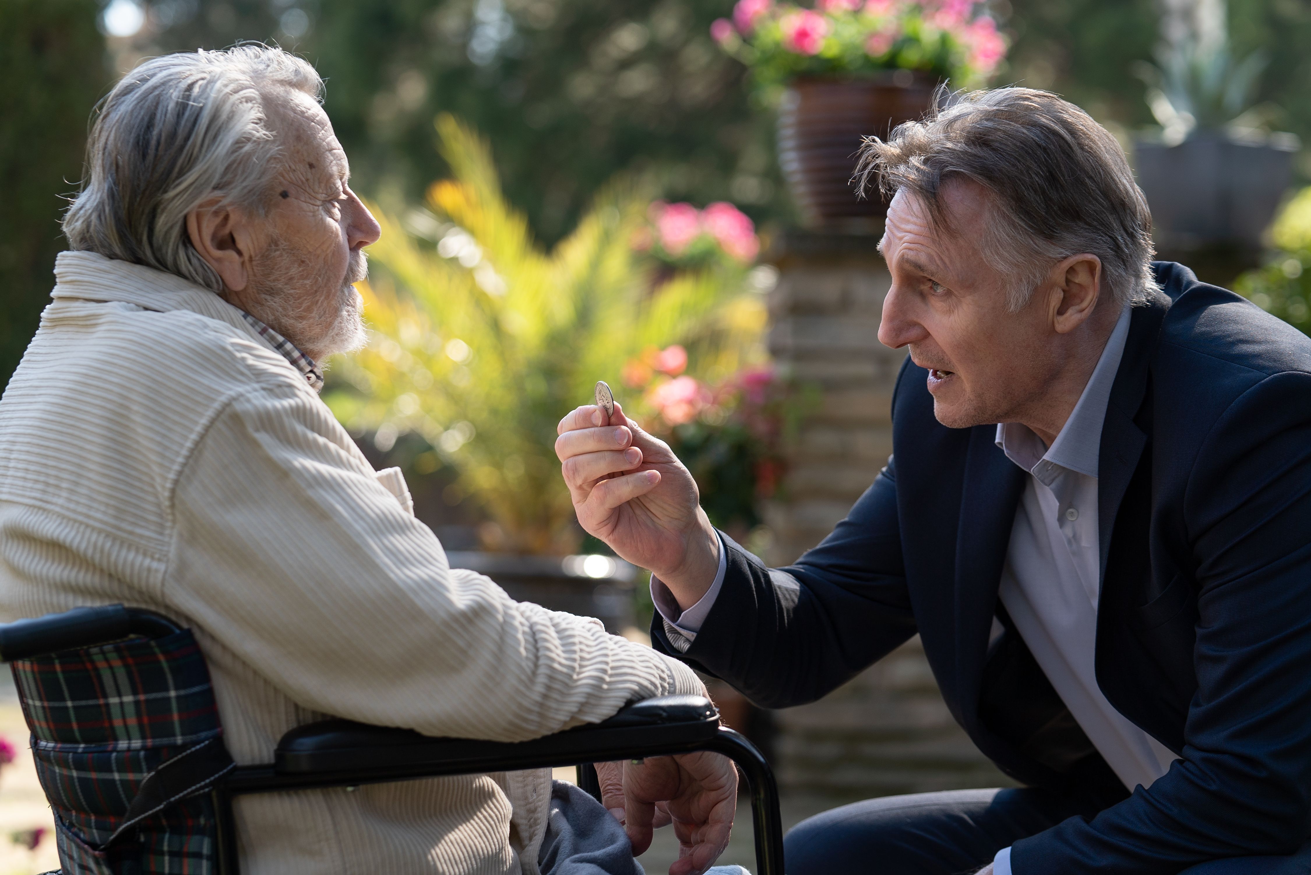 Liam Neeson giving a quarter to an elderly man in Memory