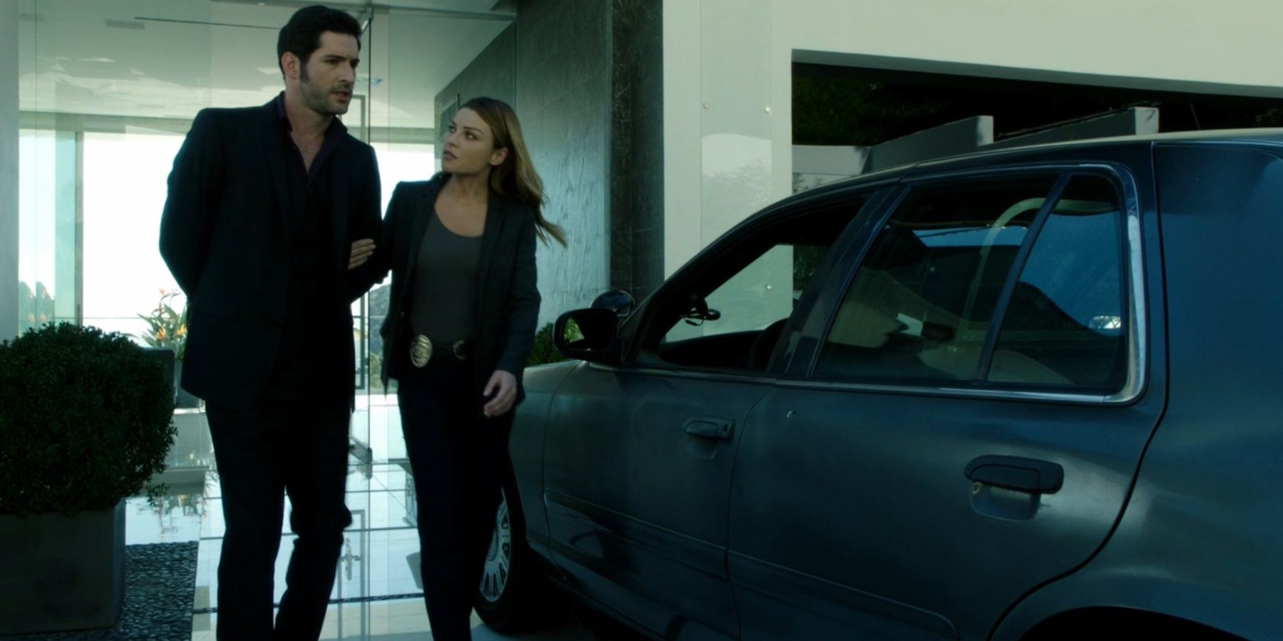 Lucifer Morningstar é algemado e levado a um carro pela detetive Chloe Decker