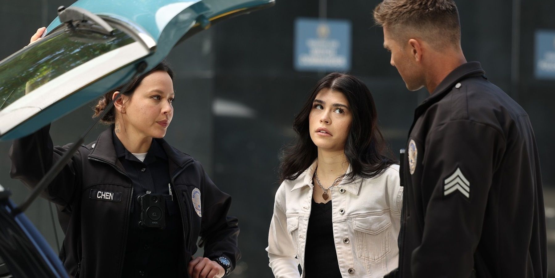 Lucy Chen and Tim Bradford stand at the rear of a hatchback car with Tamara collins on the rookie