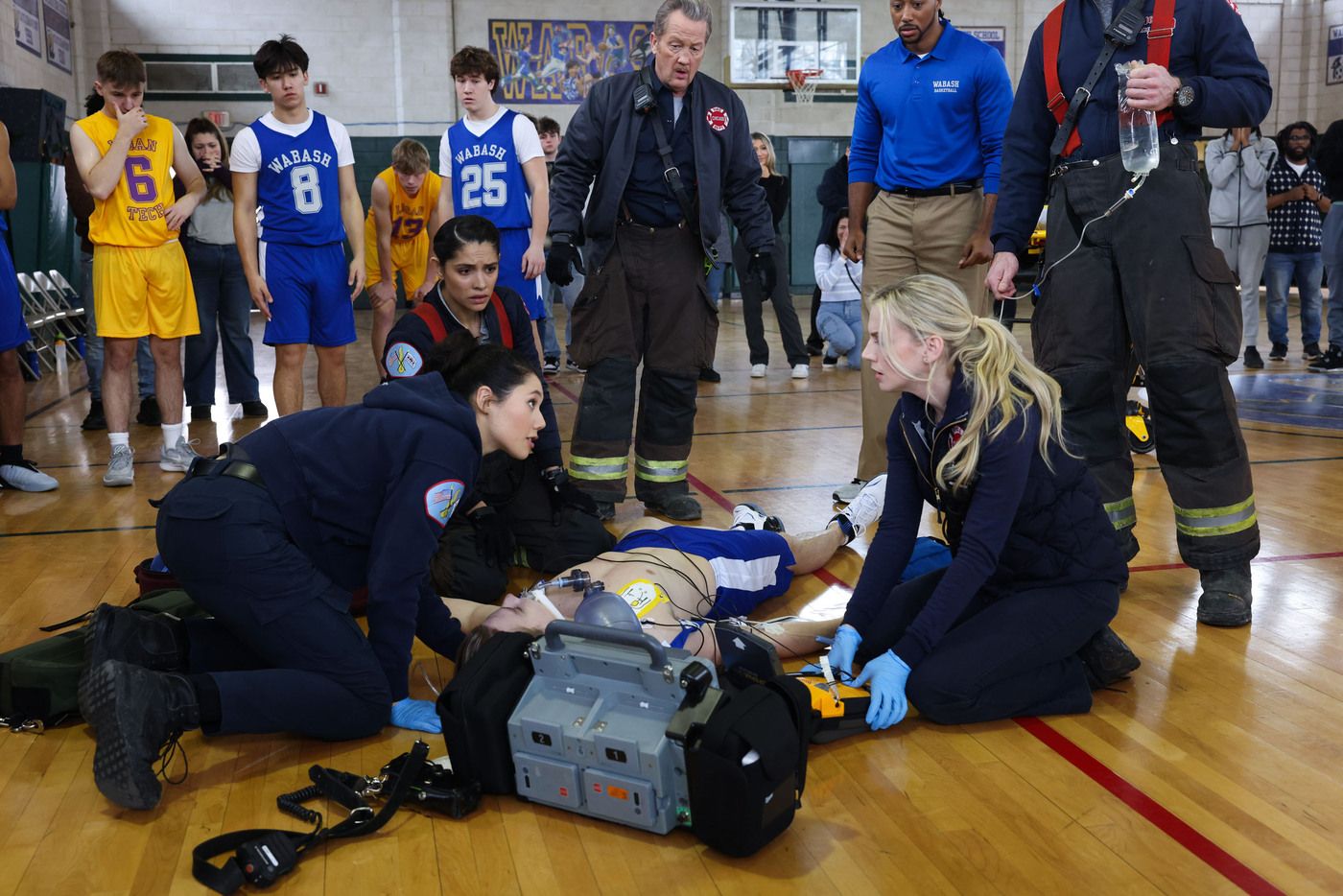 Paramedics treat an unconscious basketball player in high school gym on Chicago Fire