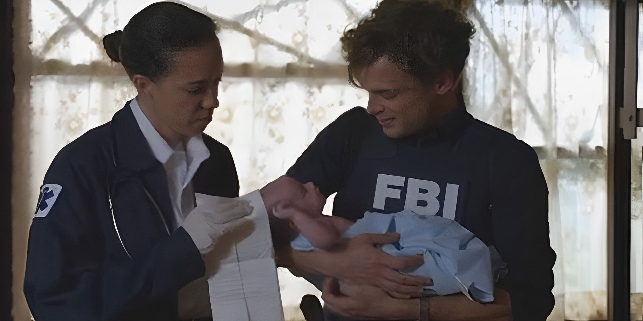 Spencer holding a newborn baby with a paramedic in Criminal Minds "Gatekeeper."