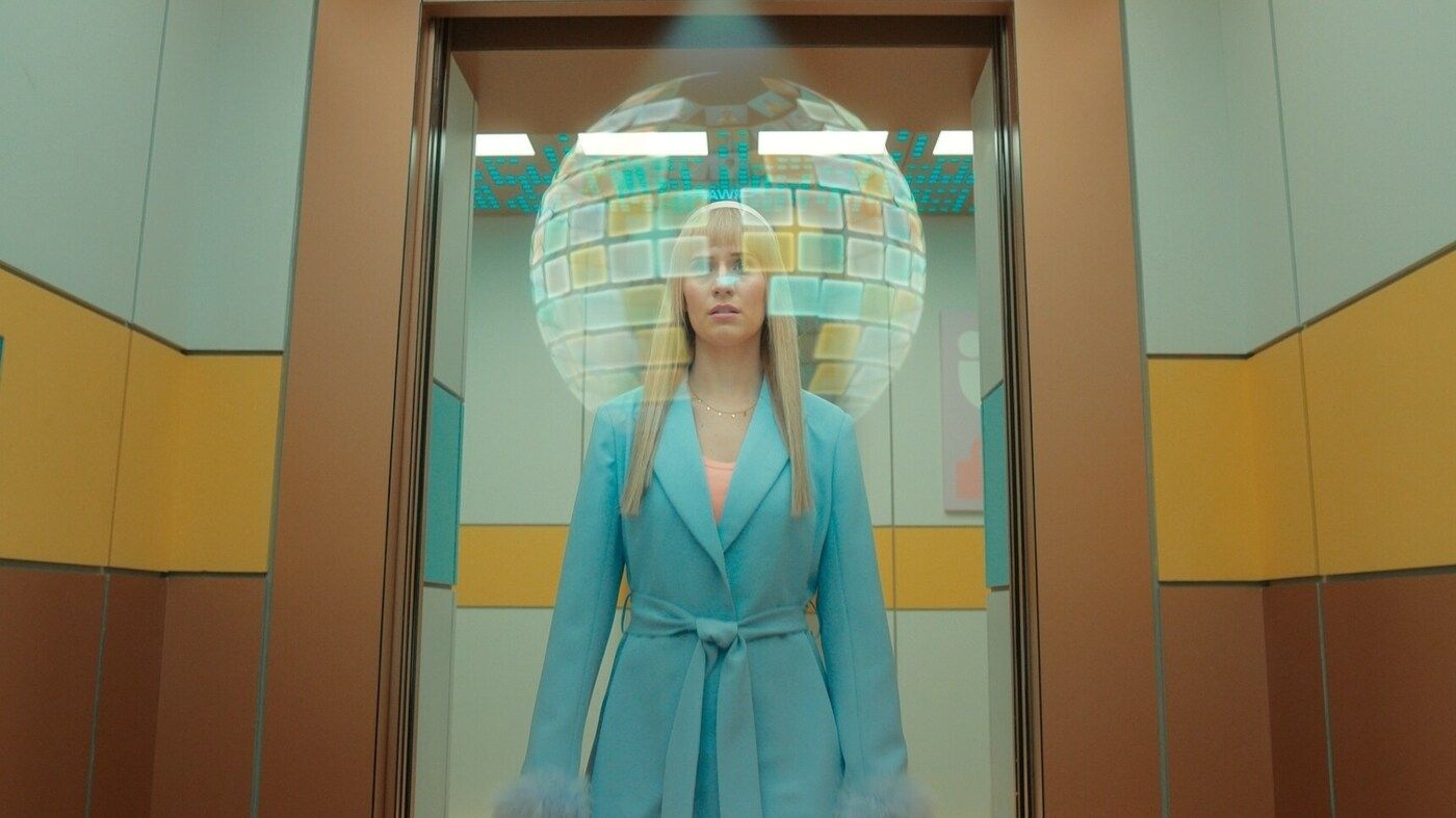Lindy (actor Callie Cooke) stands in an open elevator with Bubble around her head in Doctor Who