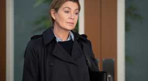 Ellen Pompeo as Meredith Grey stands in front of double doors on Grey's Anatomy