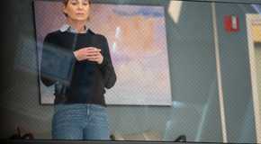 Meredith Grey (actor Ellen Pompeo) in a sweater watching a surgery on Grey's Anatomy