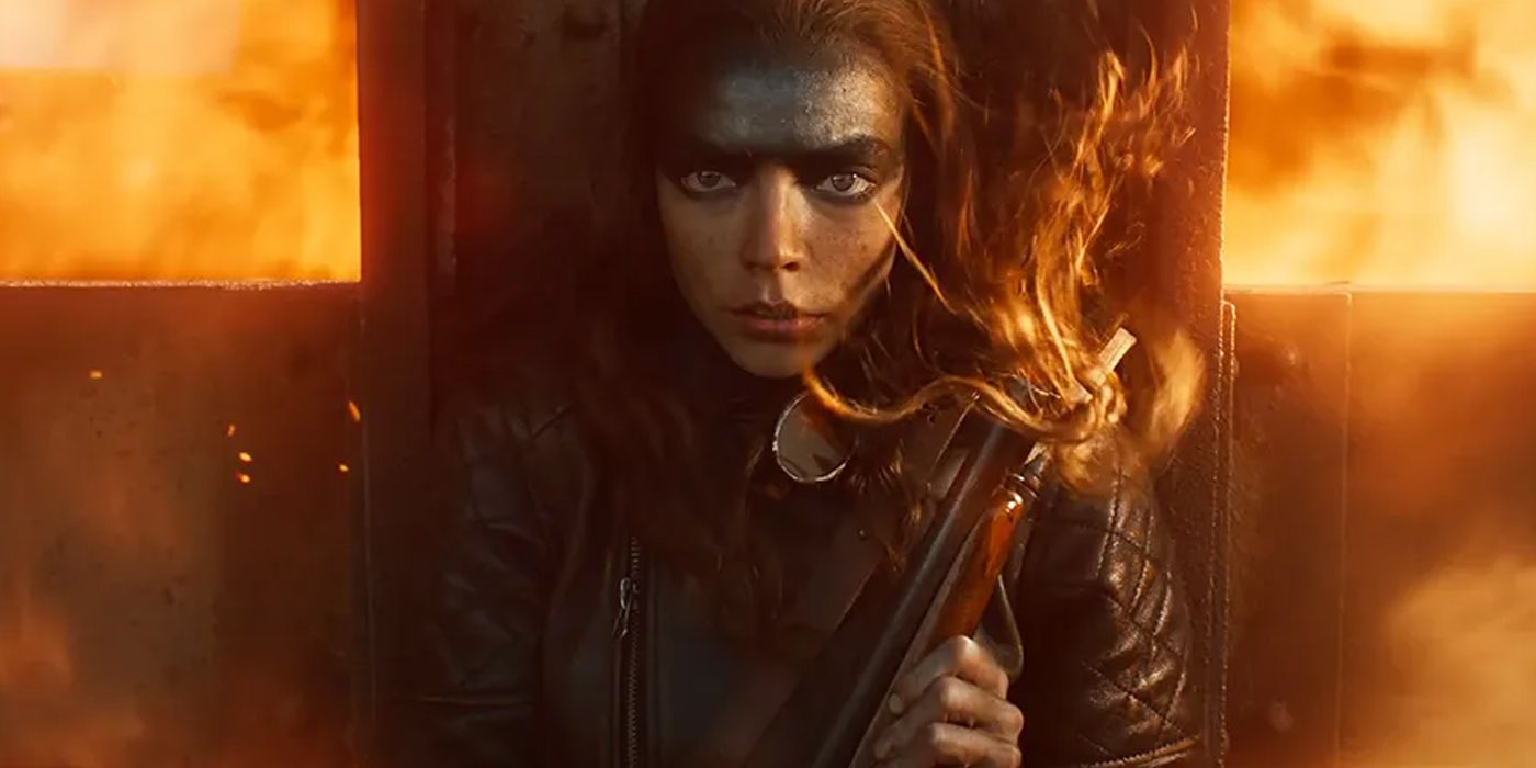 Furiosa holds her shotgun while standing in front of flames in Furiosa A Mad Max Saga