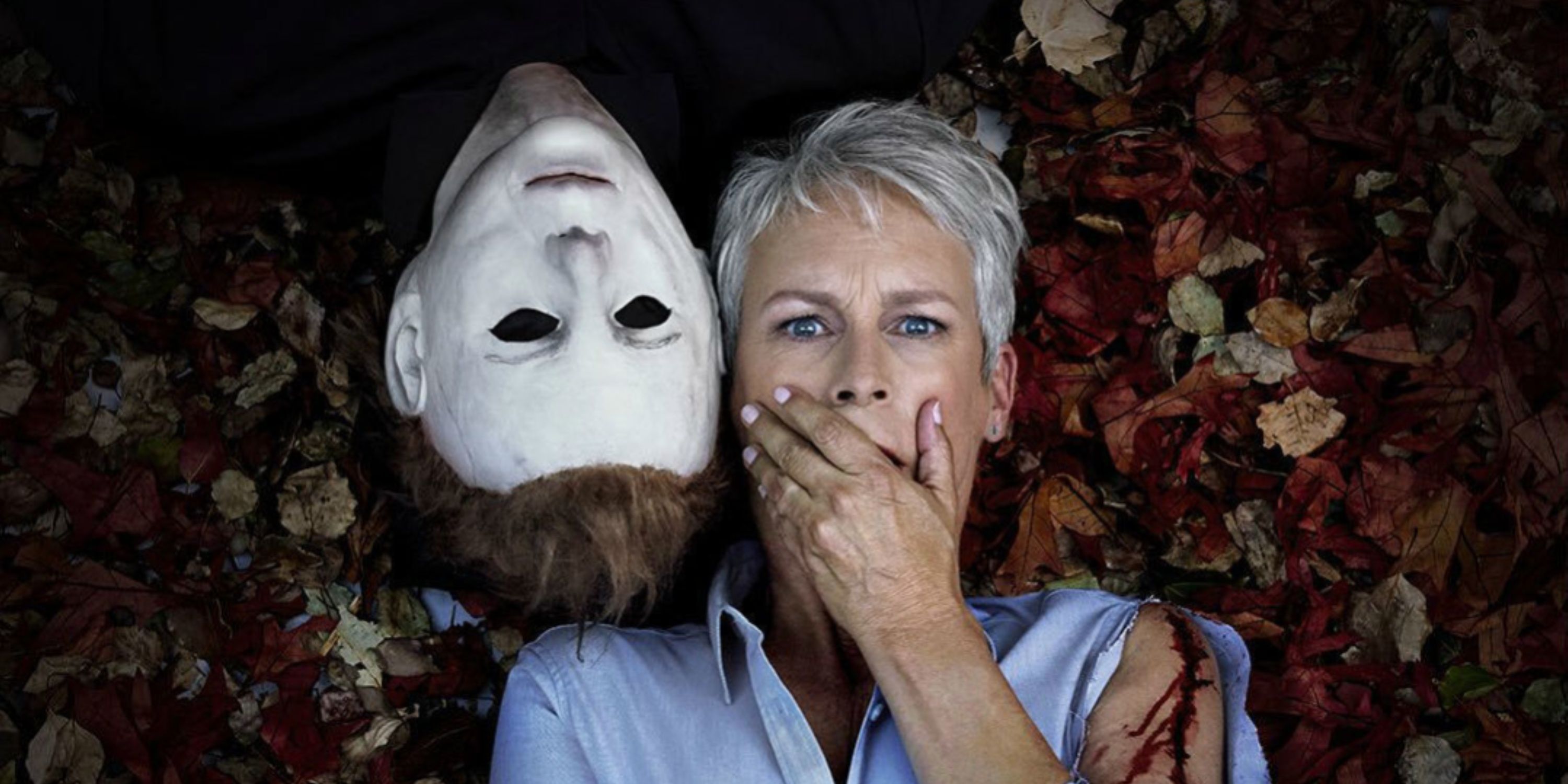 Michael Myers and Laura Strodie (played by Jamie Lee Curtis) lay next to each other in a promotional image for the Halloween franchise