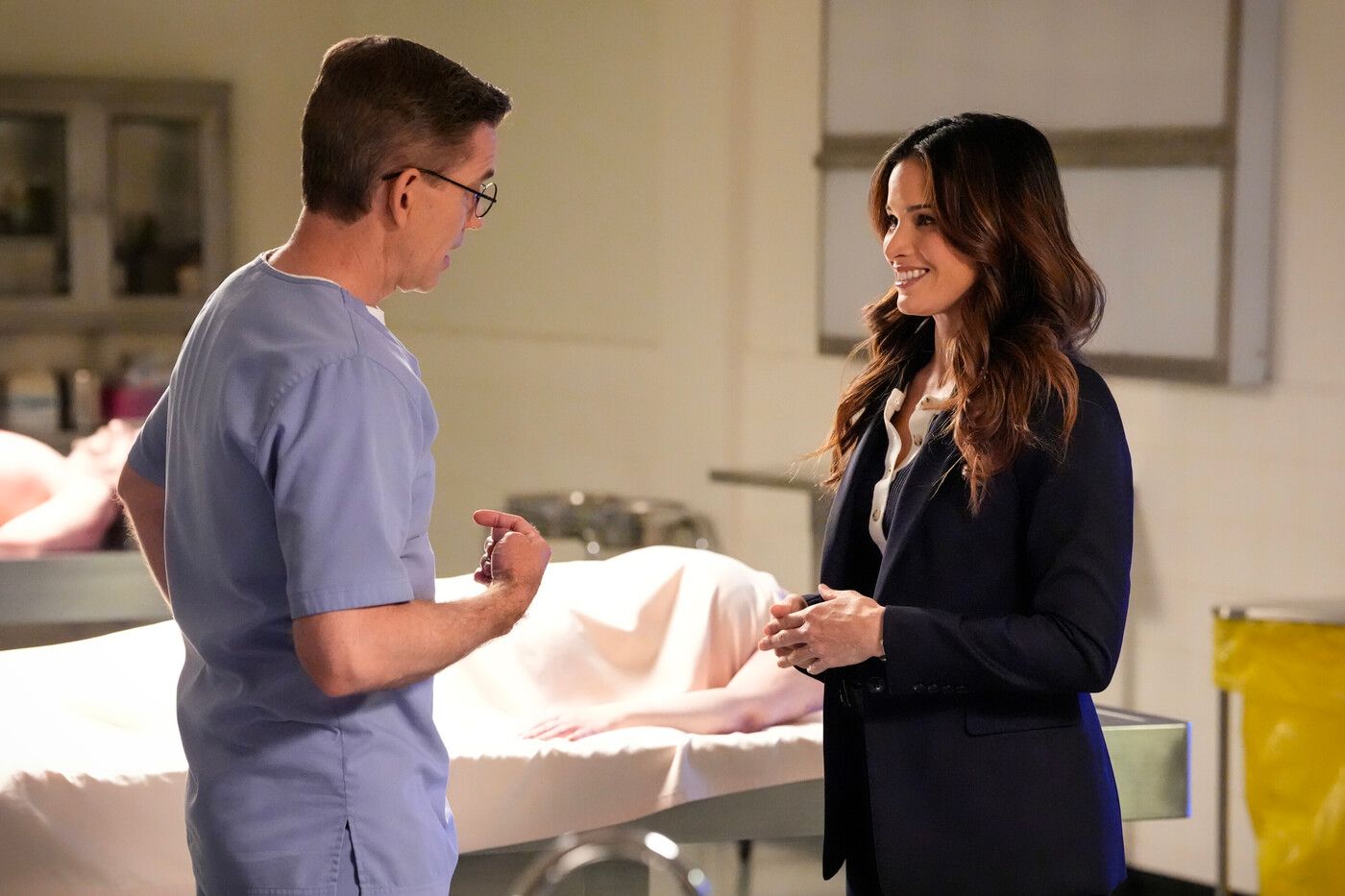 Jimmy (Brian Dietzen) and Knight (Katrina Law) talk next to a morgue table on NCIS