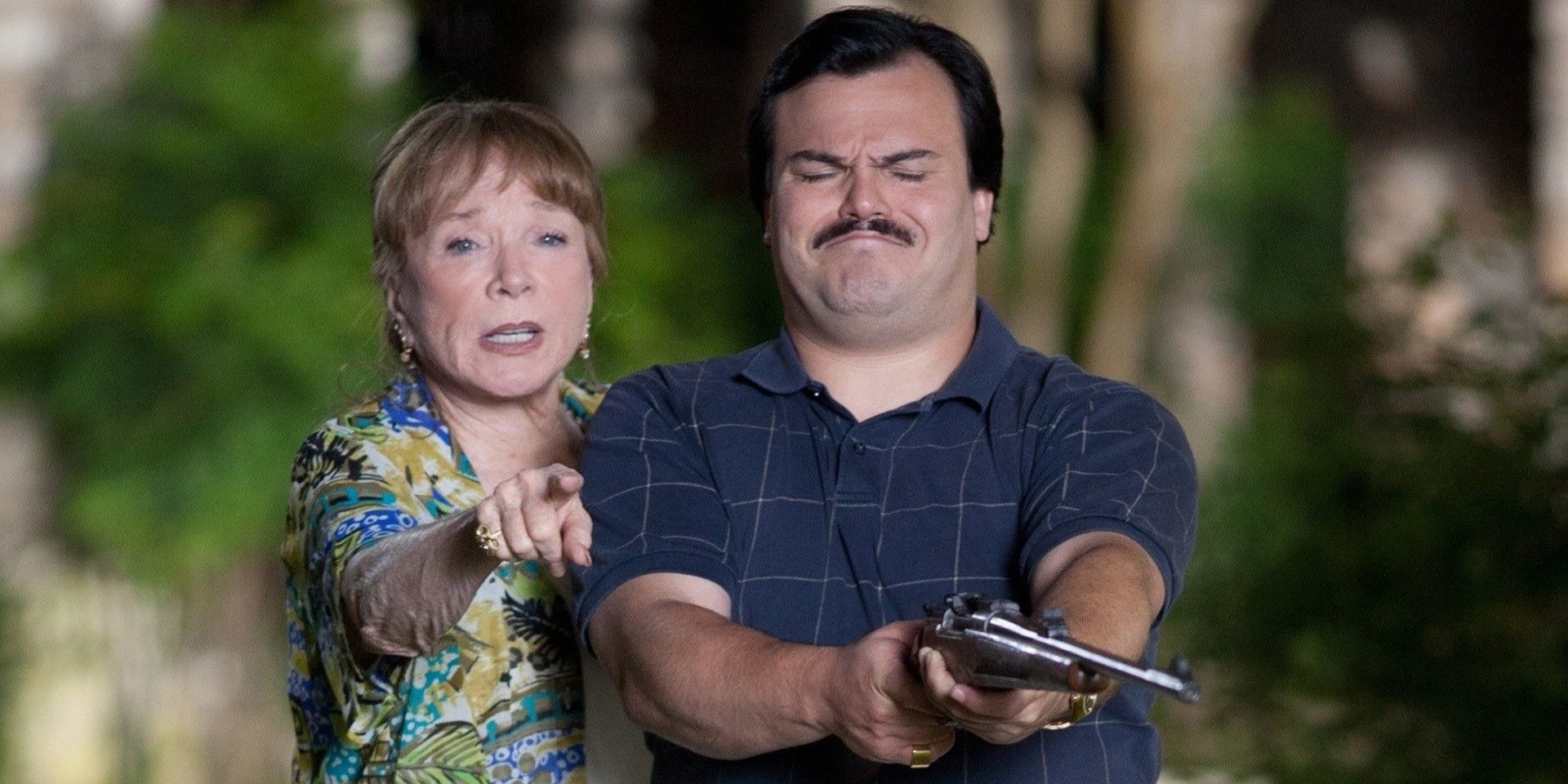 Shirley MacLaine points at something and Jack Black holds a gun in a scene in Bernie