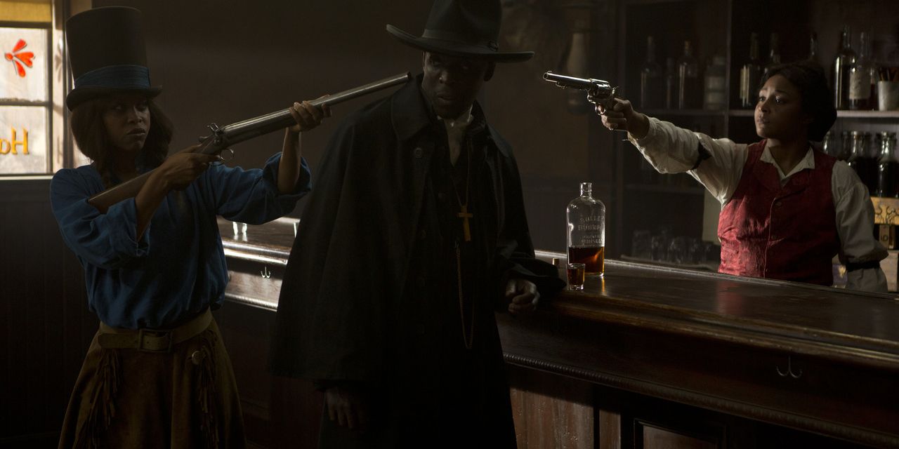 The bartender and Stagecoach Mary point guns at Nat Love in They Die By Dawn