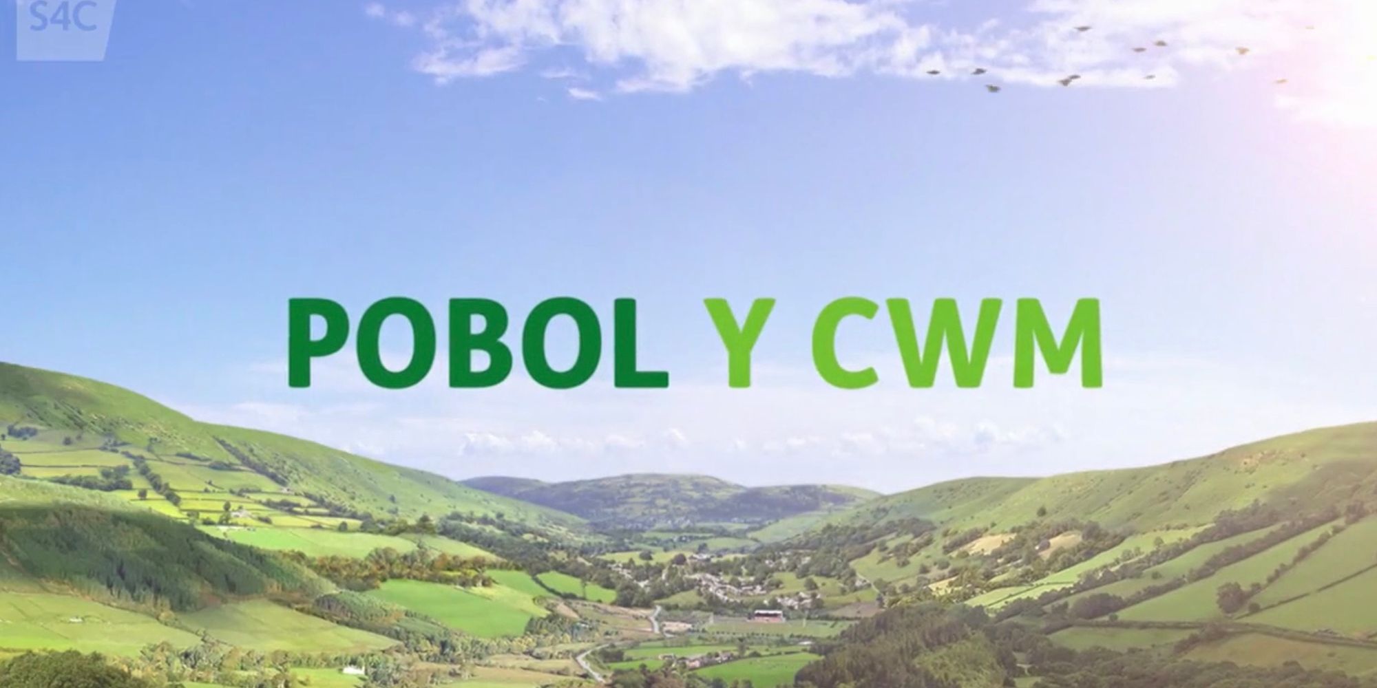 O título Pobol Y Cwm é mostrado sobre uma imagem da zona rural galesa