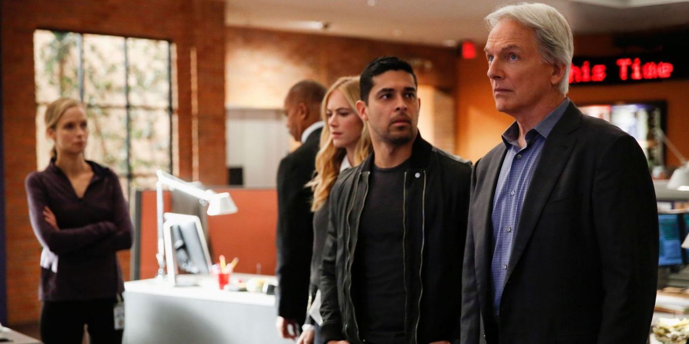The team looks up at a screen on NCIS L to R_ Emily Wickersham as Eleanor Bishop, Wilmer Valderrama as Nicholas Torres, and Mark Harmon as Jethro Gibbs on NCIS