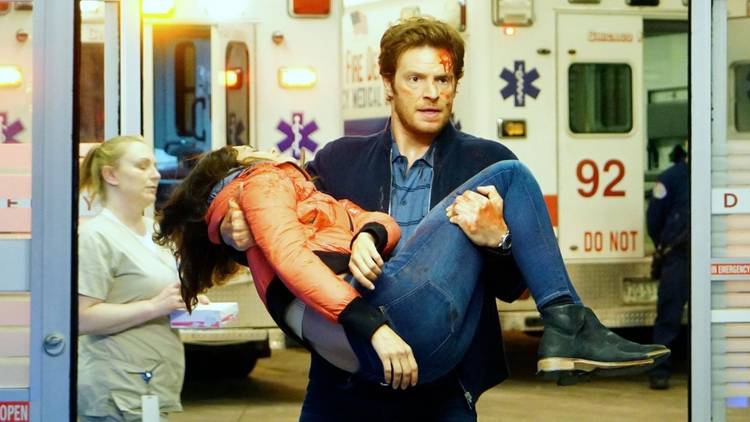 501 Nick Gehlfuss as Will Halstead carries Torrey DeVitto as Natalie Manning through the hospital doors on Chicago Med
