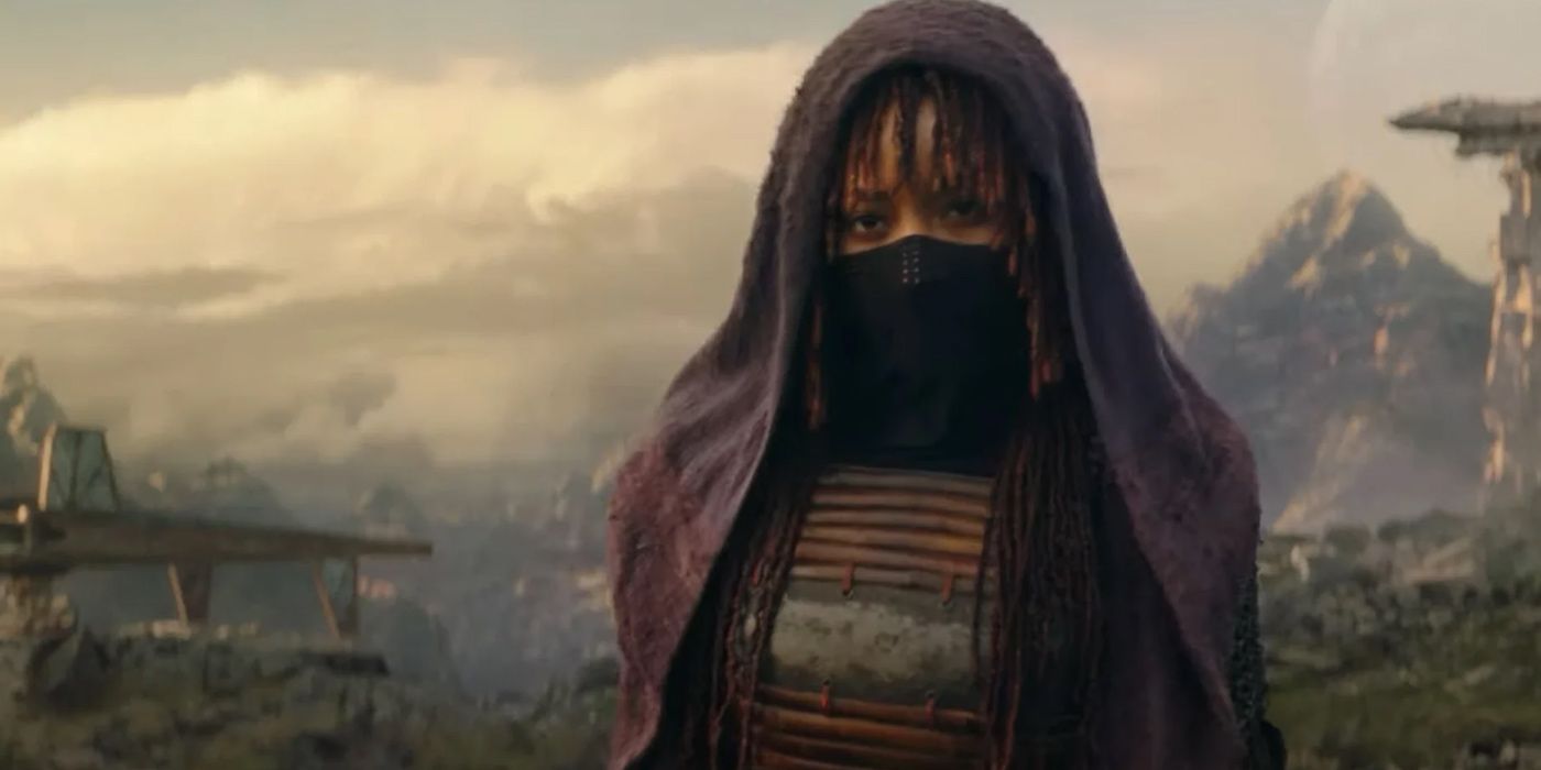 A masked Mae (Amandla Stenberg) stands in front of the mountains in The Acolyte