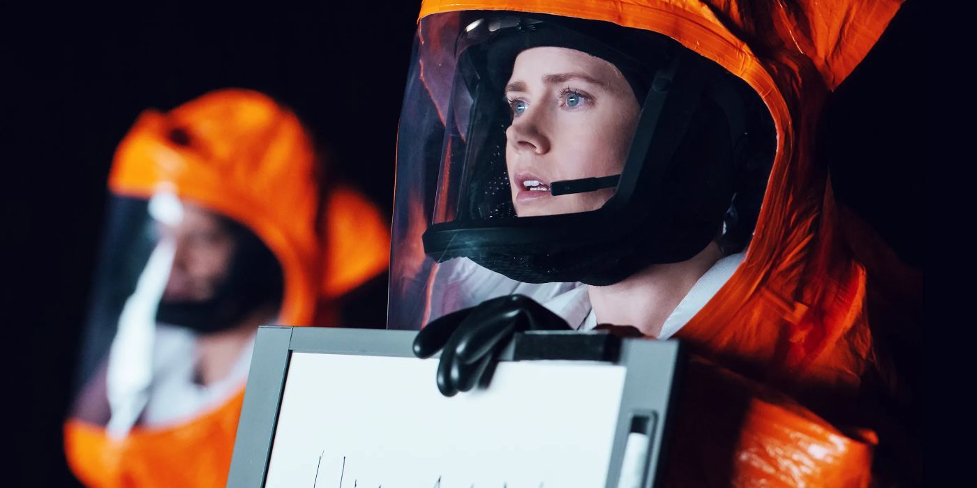 Dr. Louise holding a small white board in Arrival