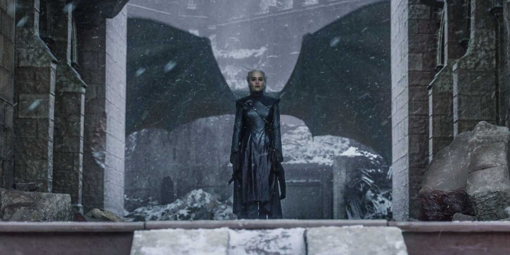 Daenerys Targaryen stands framed in front of dragon wings in Game of Thrones