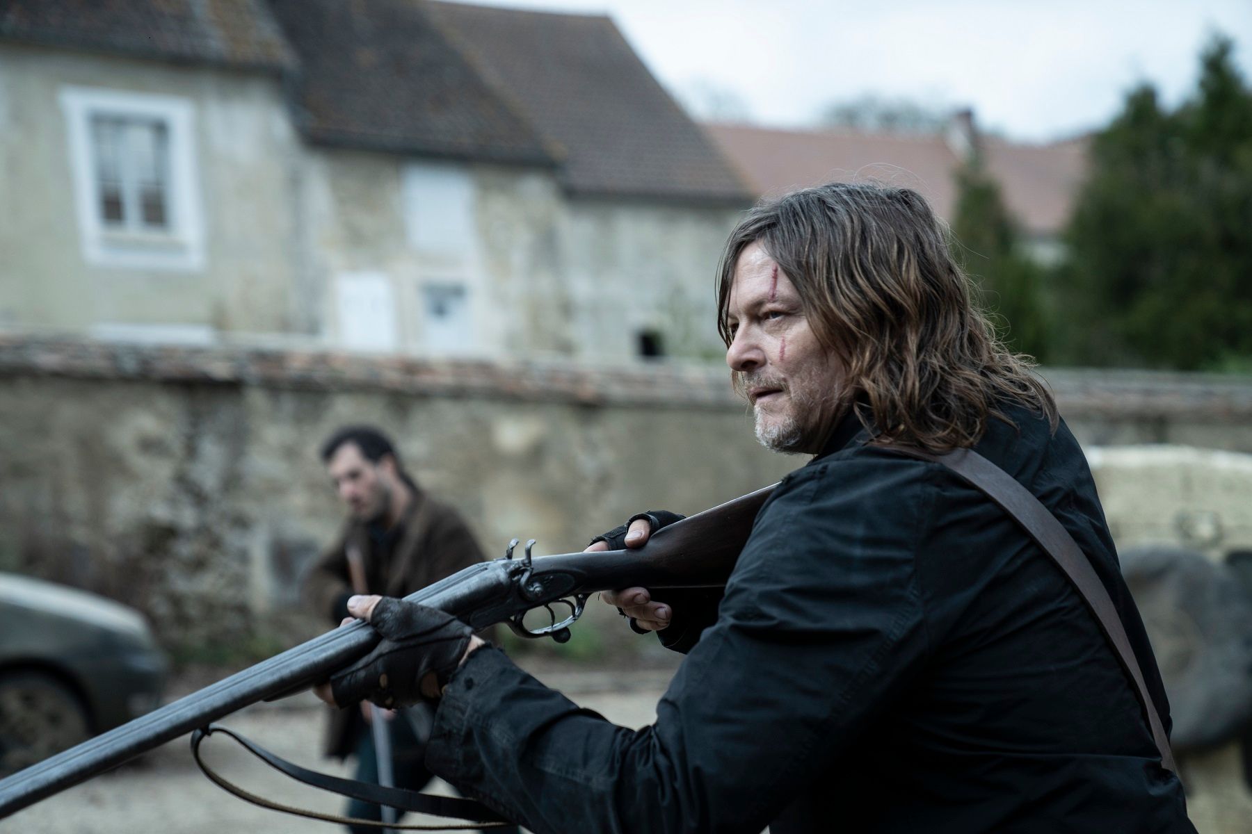 Norman Reedus as Daryl Dixon holding a firearm in The Walking Dead: Daryl Dixon - The Book of Carol