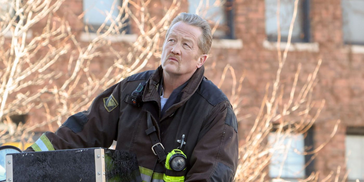 Mouch (actor Christian Stolte) in firefighter gear on top of the truck in Chicago Fire