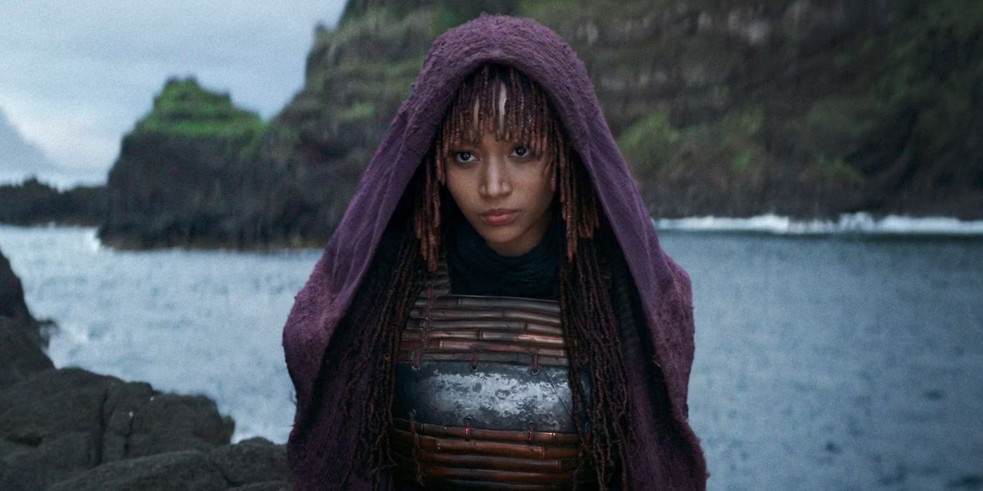 Mae (Amandla Stenberg) stands in front of a lake in The Acolyte